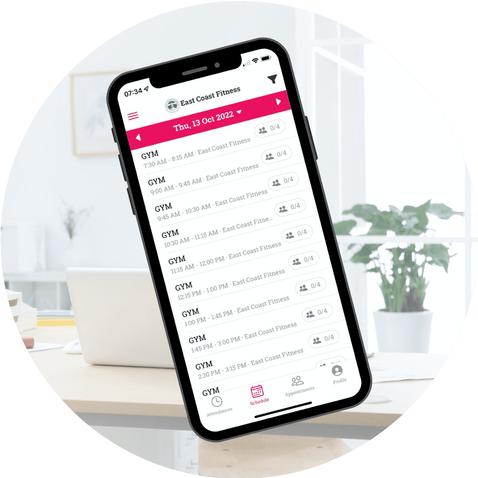 Smartphone displaying the East Coast Fitness schedule for gym sessions on October 13, 2022, in a bright indoor setting.